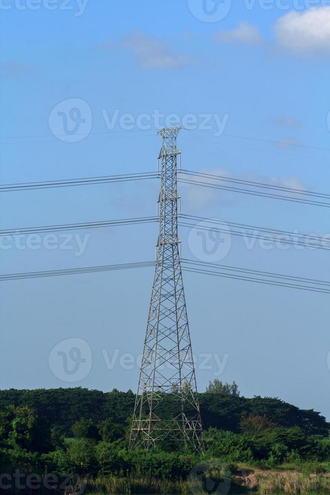 High Voltage Poles - Long-term lakeside high-voltage poles are being built by experienced engineers to provide people with electricity and consumer services. photo