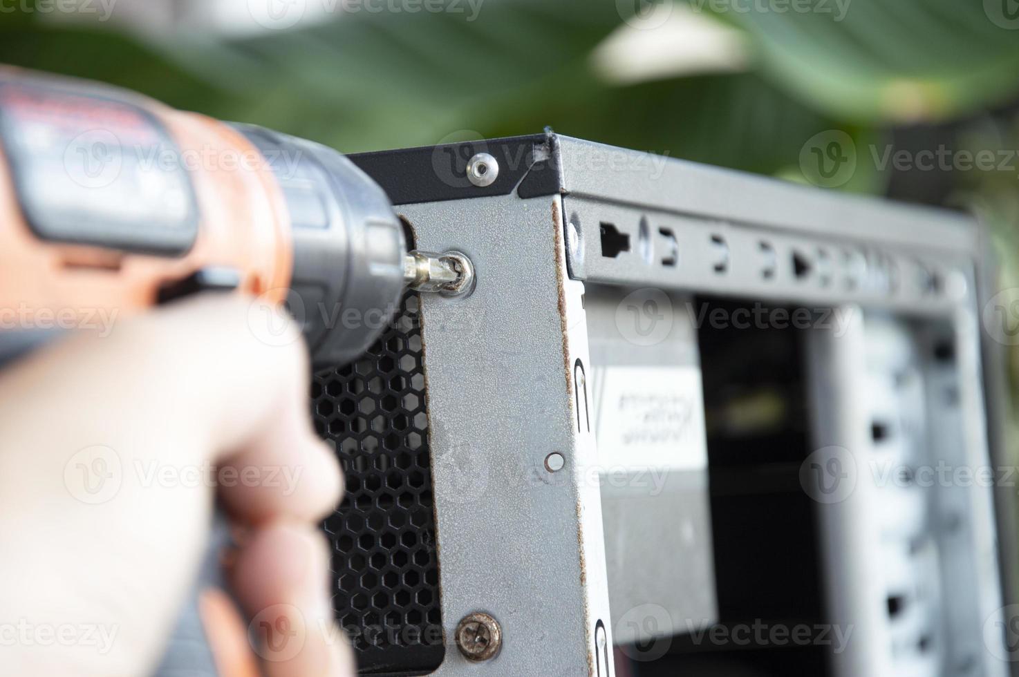 Technician screwing the back of the computer, fixing the computer photo