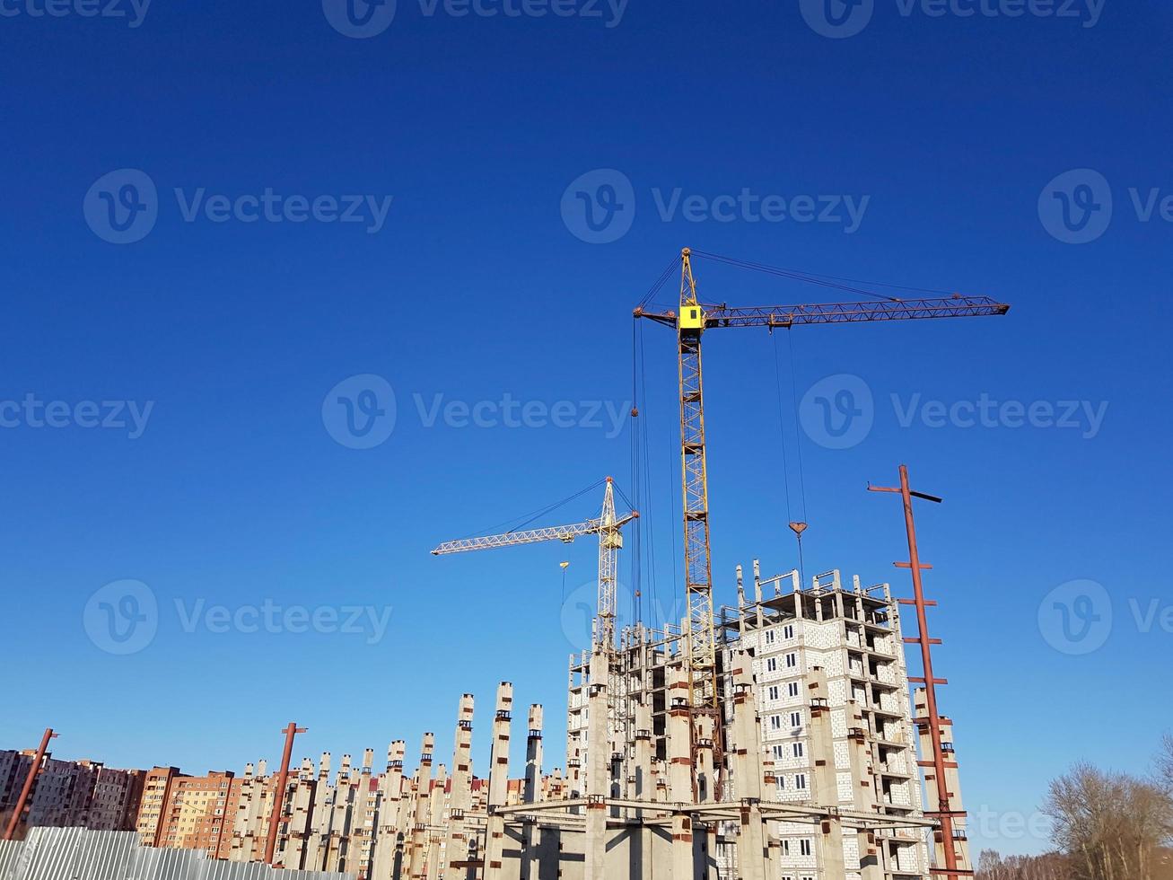 muchos edificios de gran altura y grúas en construcción bajo el cielo azul foto