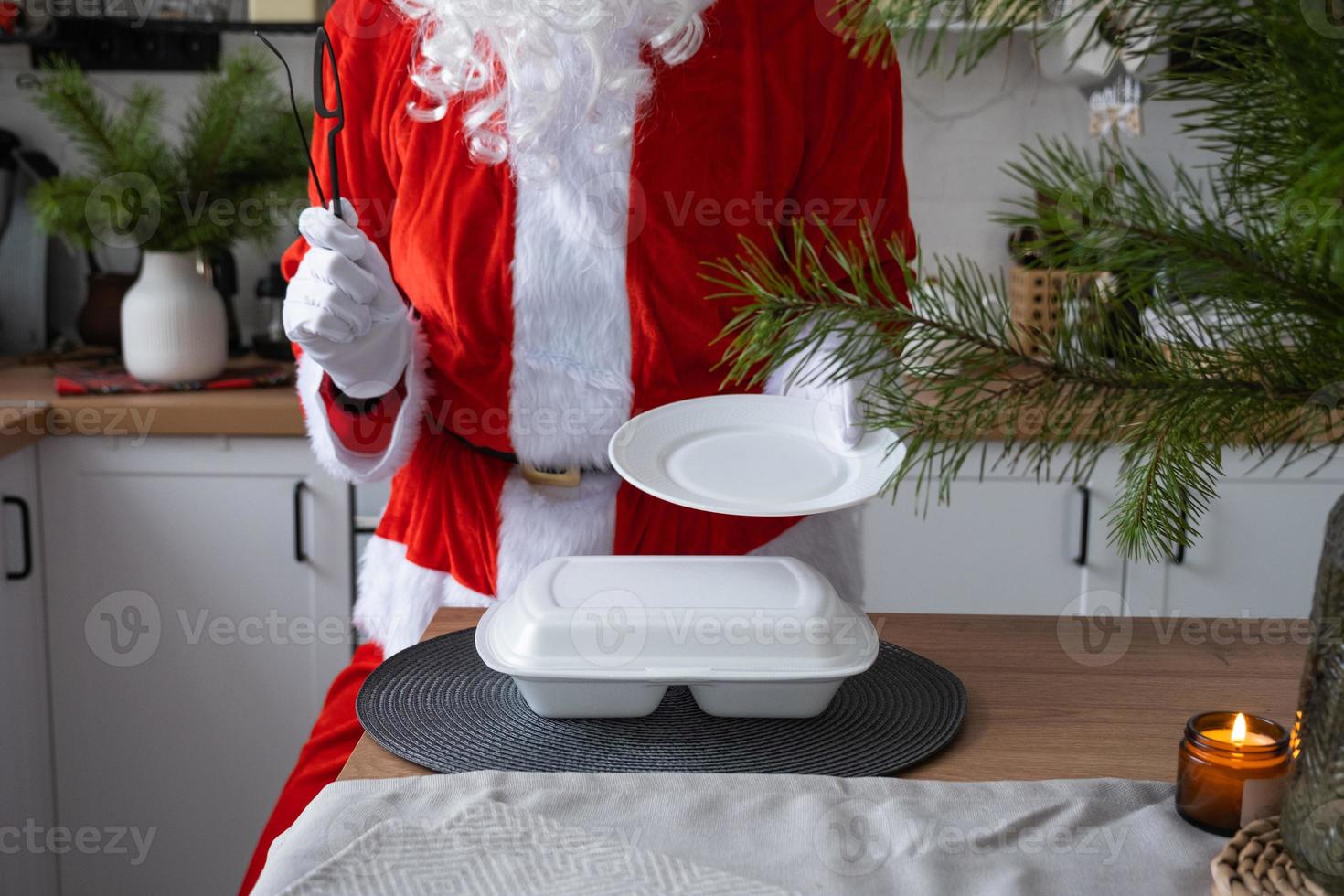 Food delivery to home service containers in hands of Santa Claus puts it on kitchen table and takes it away. Ready-made hot order, Christmas, New year holidays catering. photo