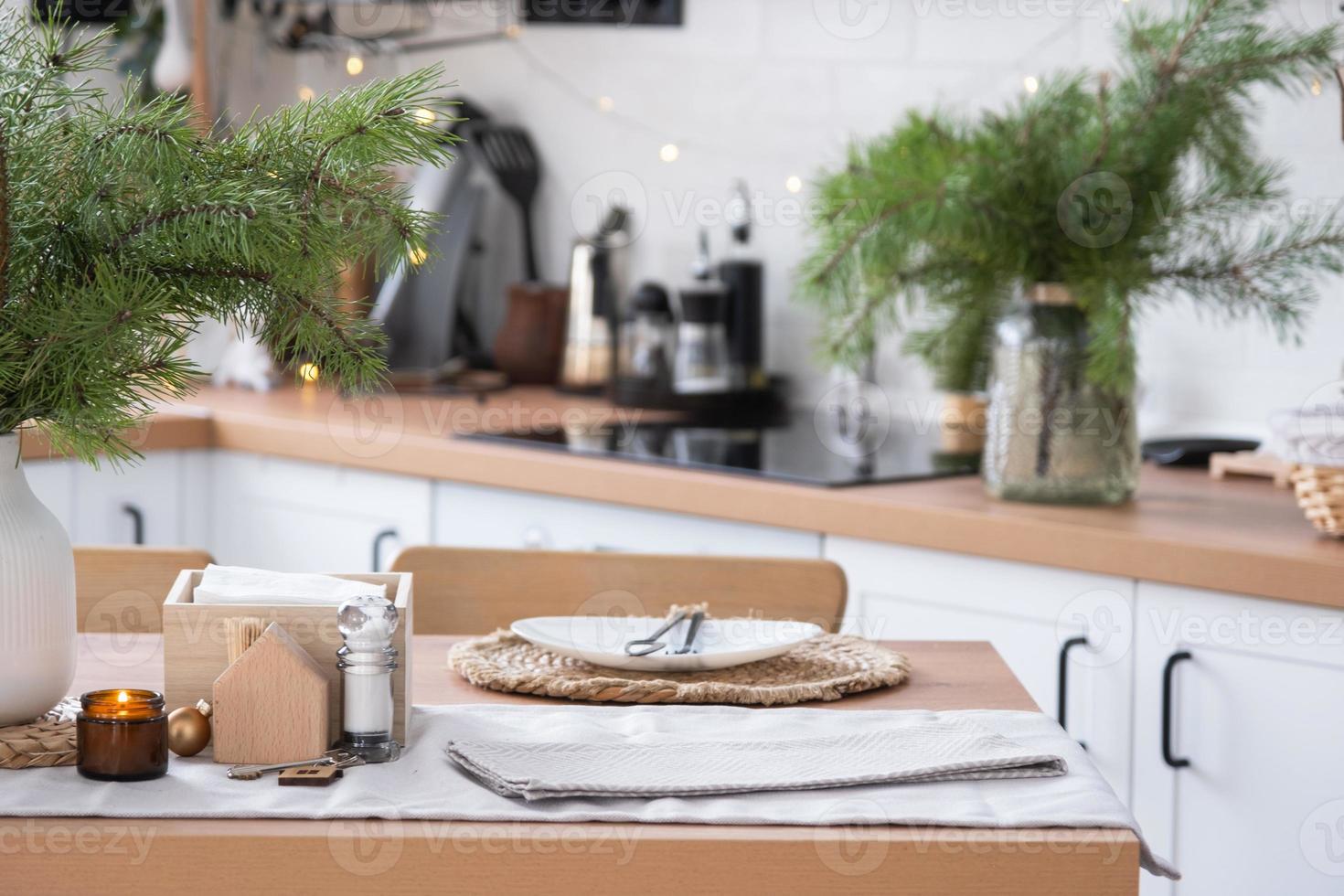 Festive Christmas decor in white kitchen, festive breakfast, white scandi interior. The figure of a cozy house ion the set table. New Year, mood, cozy home. Copy space photo