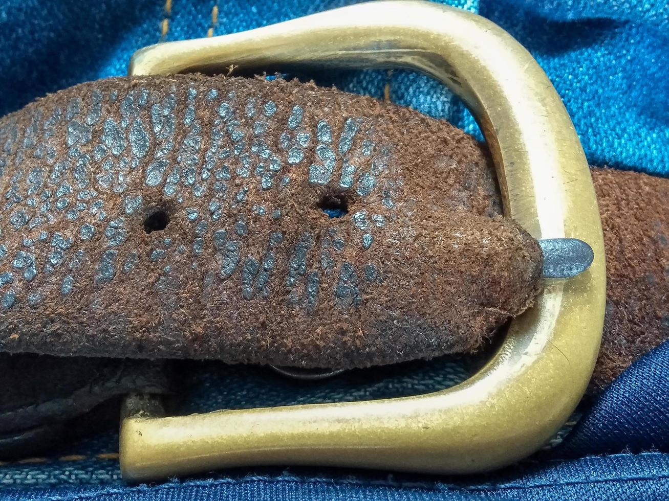 Old brown leather belt with brass buckle concept cowboy retro old fashioned photo