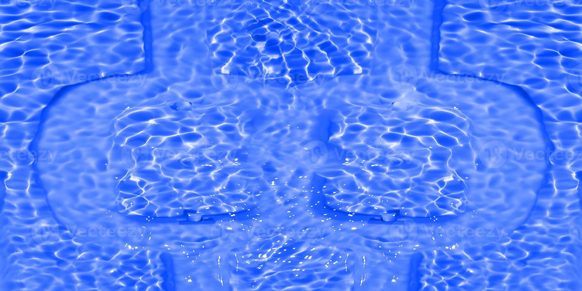 Defocus blurred transparent blue colored clear calm water surface texture with splashes and bubbles. Trendy abstract nature background. Water waves in sunlight with caustics. Blue water shinning photo