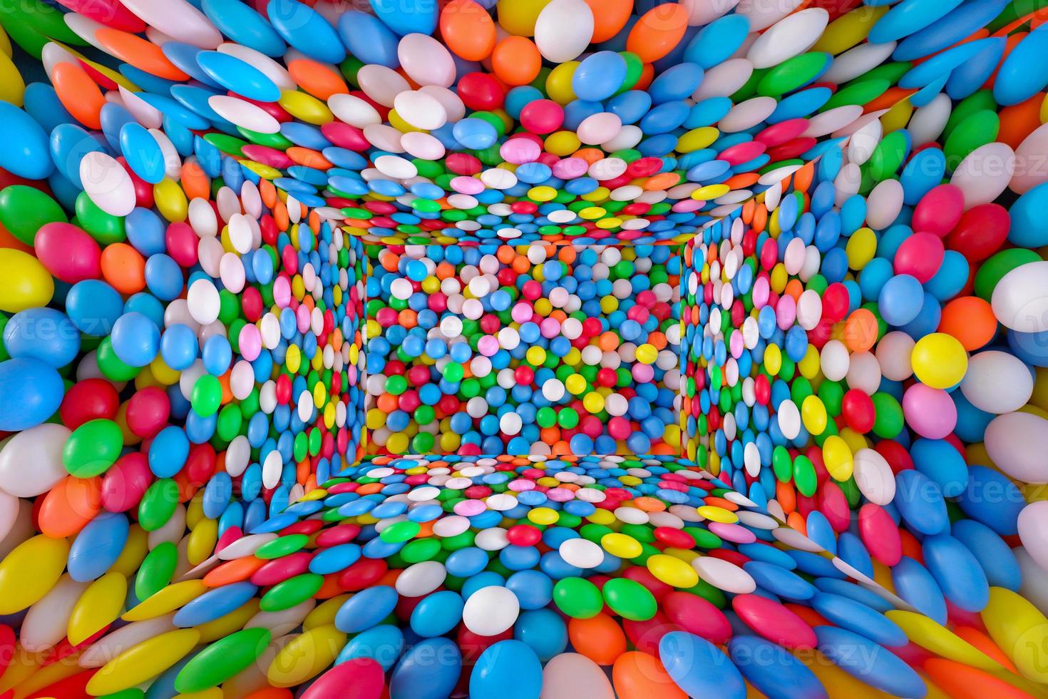 Multi colored, highly saturated plastic balls, in soft play ball pit, at a child's play park. Colorful balloon room background texture. photo