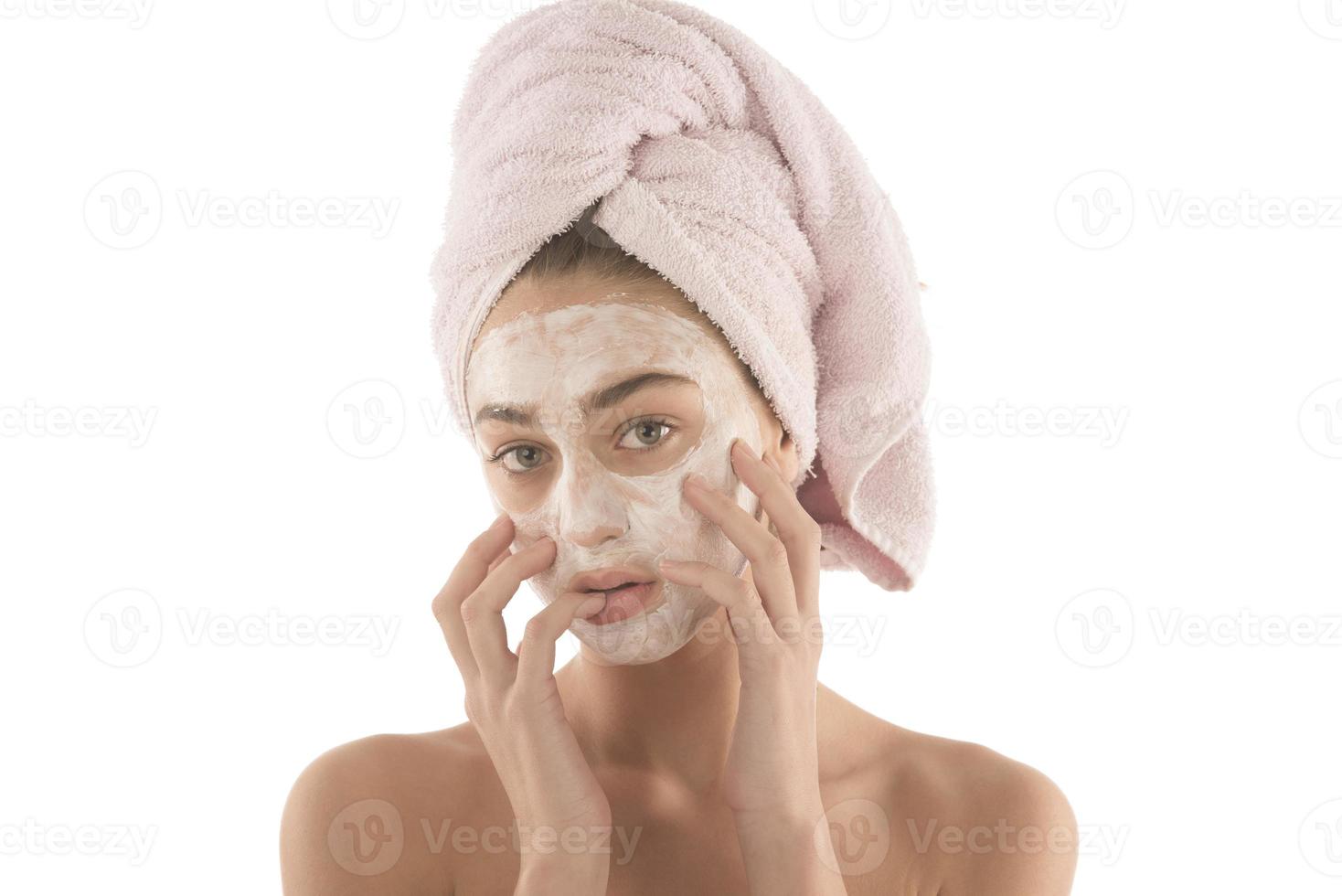 Beautiful woman with eyes closed and white clay facial mask on face isolated on white background photo