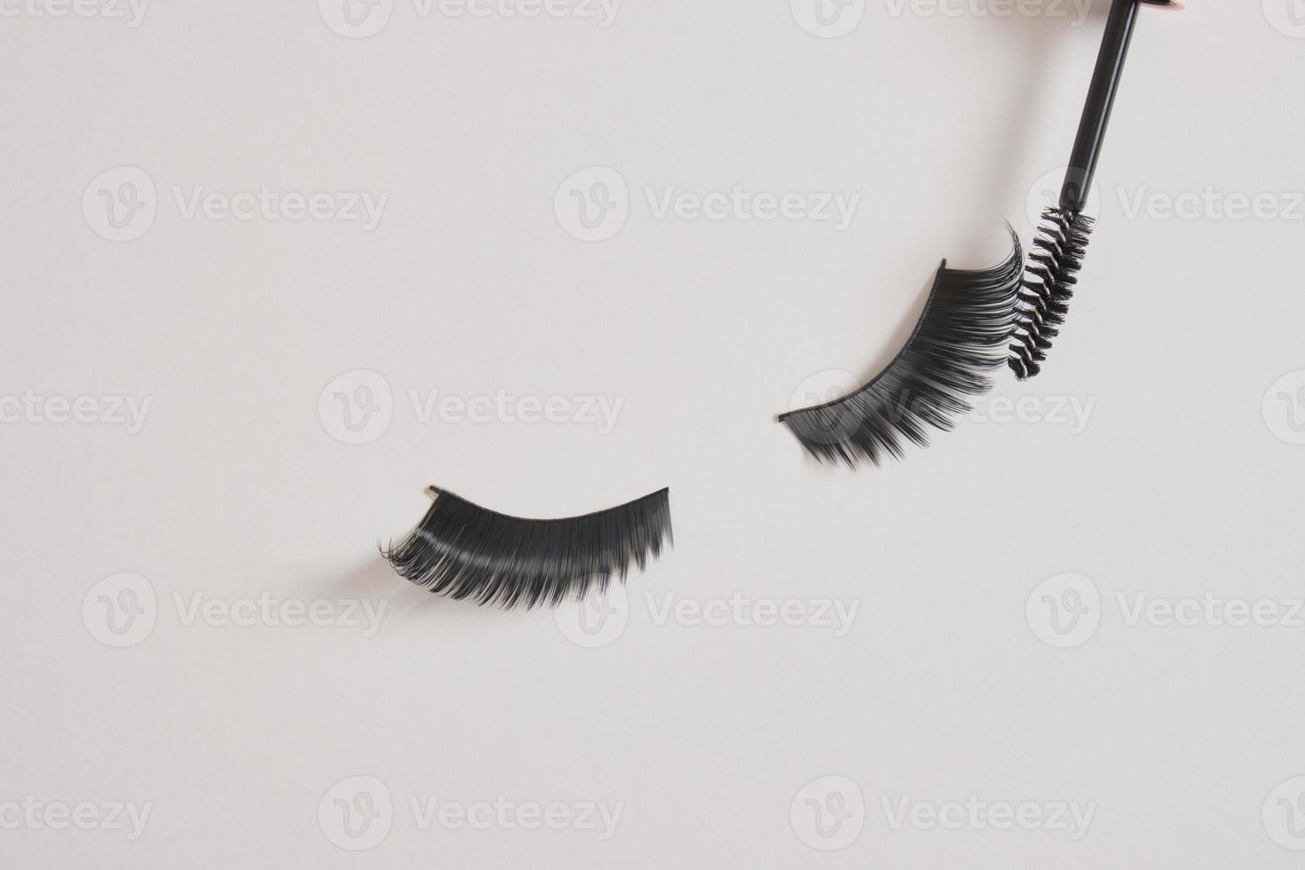 eyelashes makeup. Mascara and false eyelashes on gray background top view copy space photo