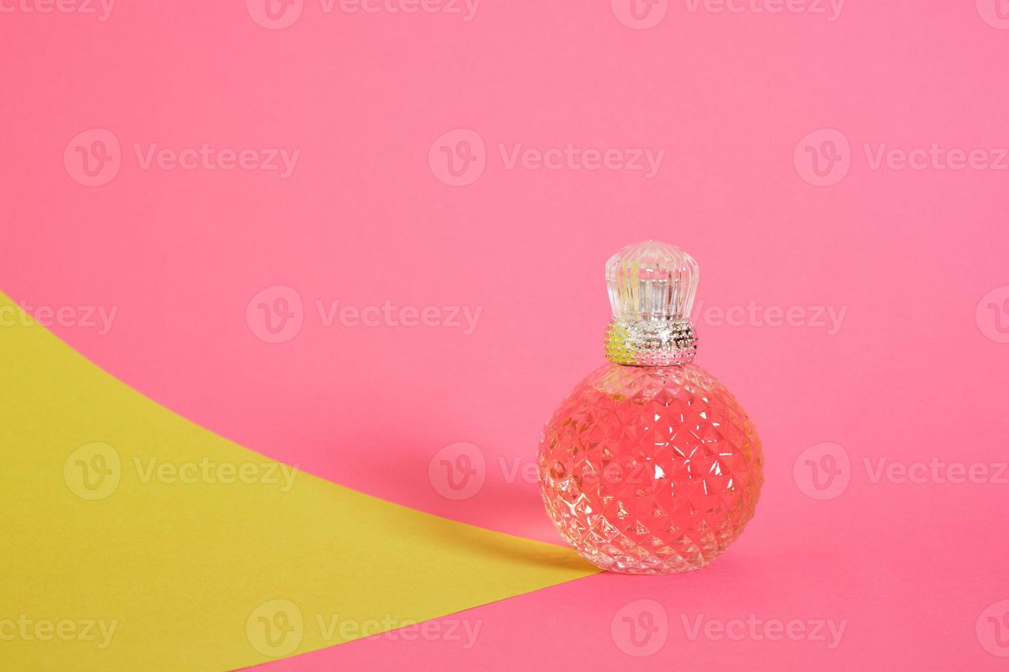 cristal glass perfume bottle on pink background photo
