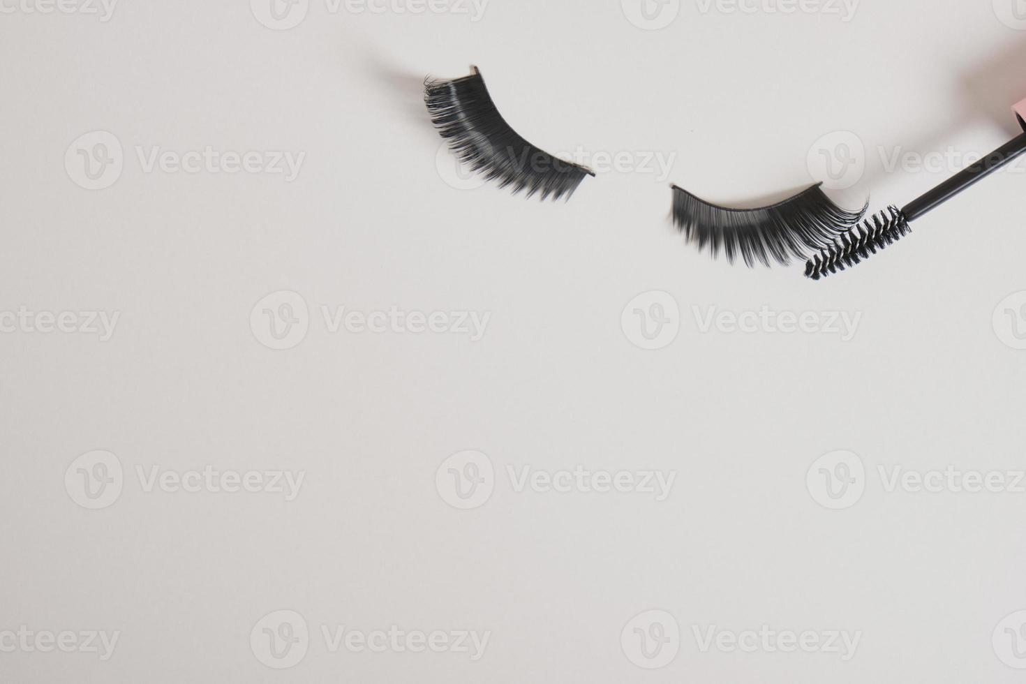 eyelashes makeup. Mascara and false eyelashes on gray background top view copy space photo