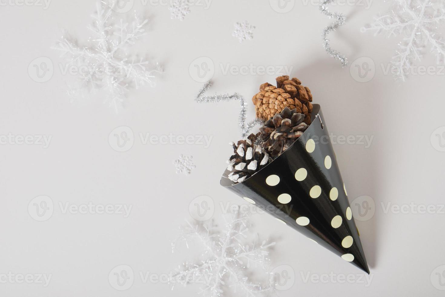 paper homemade party hat and christmas decor on a gray background, postcard copy space for the new year photo