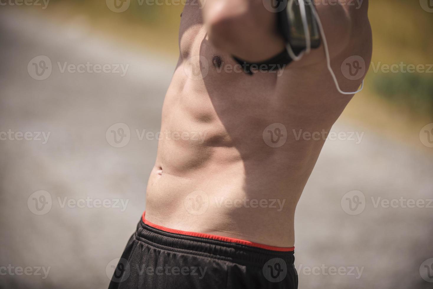 Athletic young man stretching after run in the nature. sport concept photo