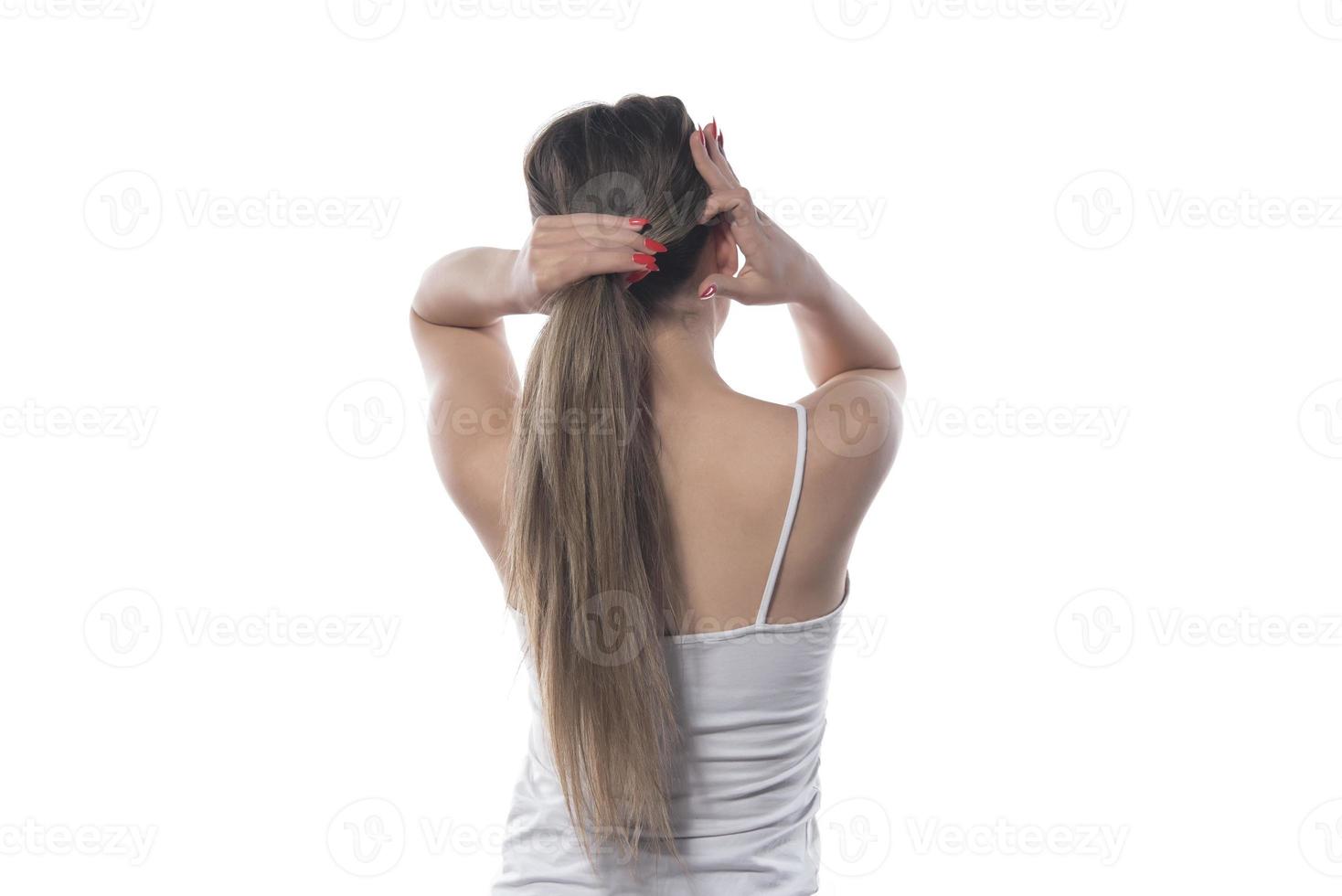 A young beautiful woman tied her hair with a rubber band photo