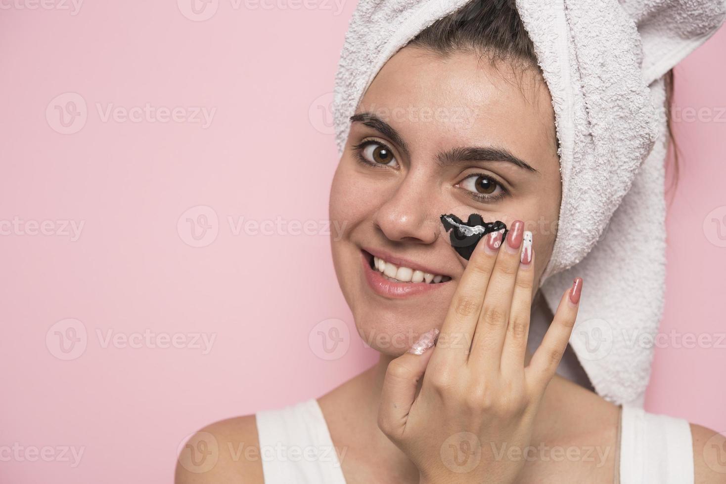 Woman with purifying black mask on her face photo