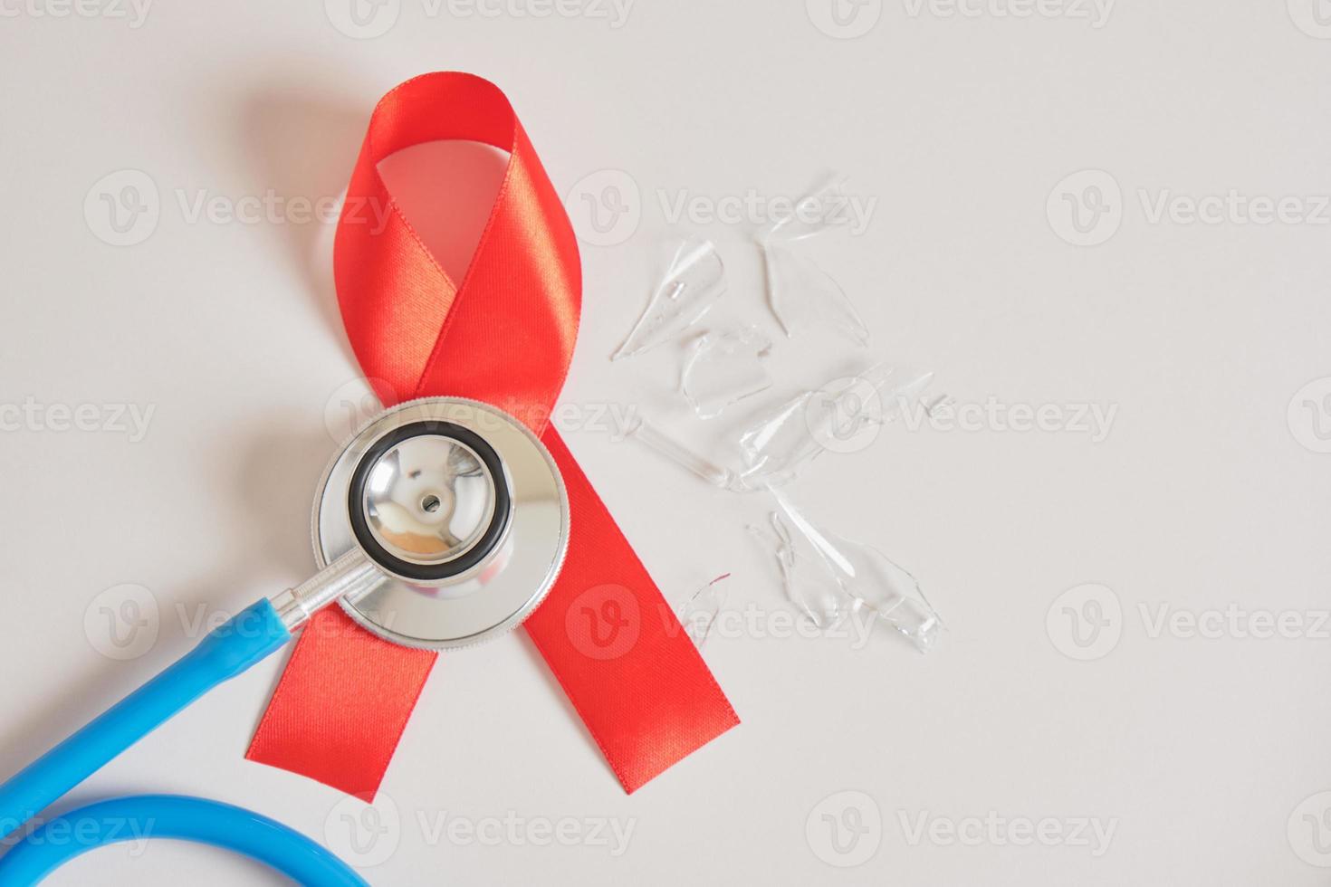 Red ribbon and blue medical stethoscope Healthcare and safe sex concept. photo