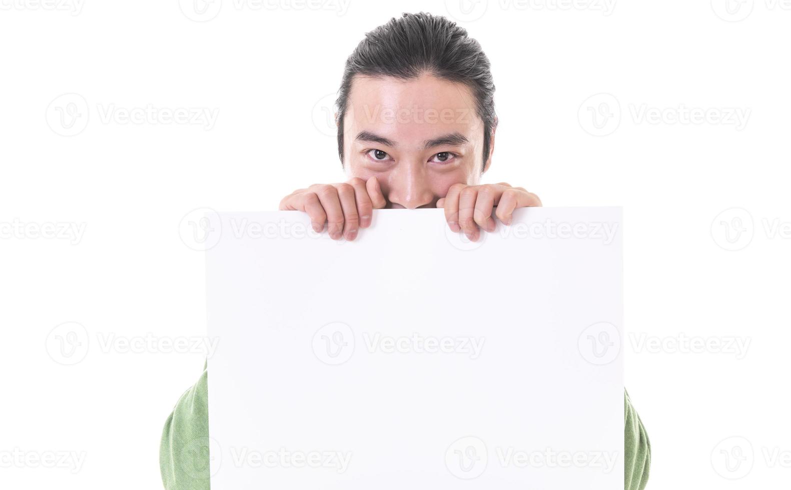 Portrait of young Asian man peeping at the camera holding white blank sign photo