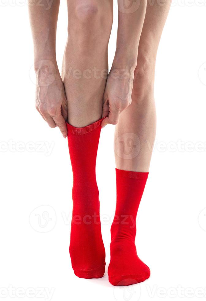 Girl putting on stockings at home. Beautiful female legs. photo