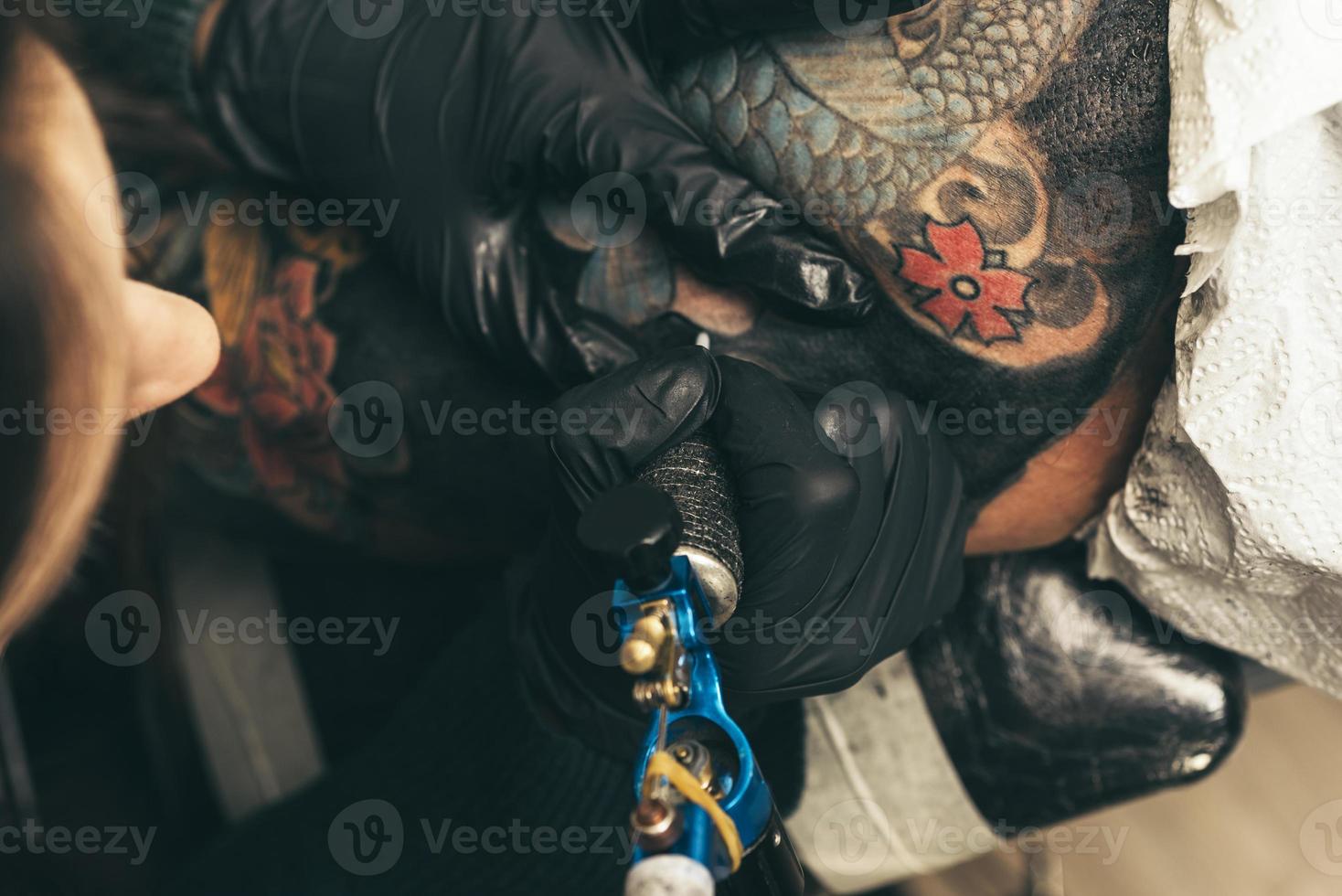 close up tattoo machine. Woman creating picture on hand with it in salon photo