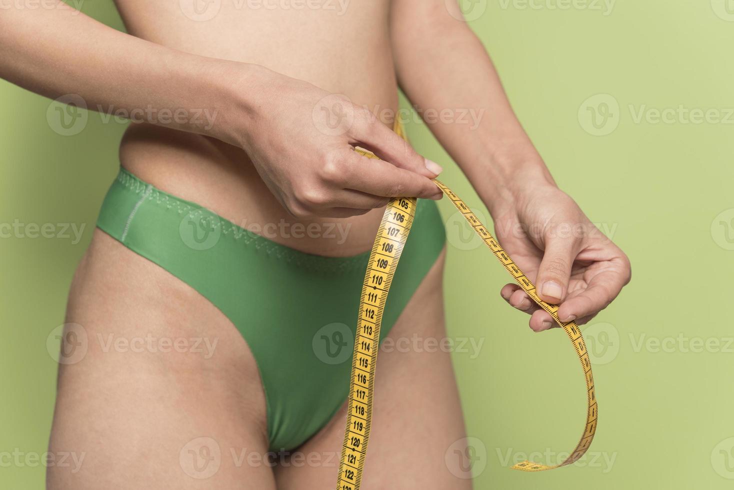 girl measures her volumes with a measuring tape. healthy and beautiful body. Female body, slim waist photo