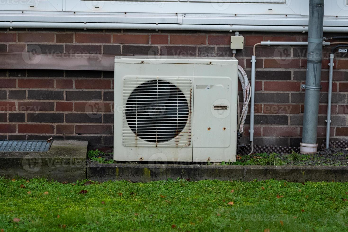 old rusty air conditioner on a brick wall photo