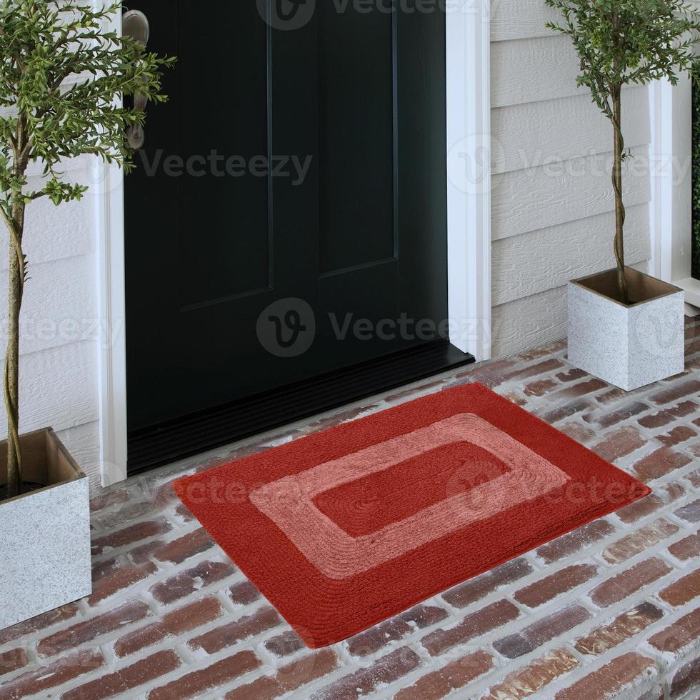 Designer Welcome Entry Doormat Placed on Solid Brick Floor Outside Entry Door with Plants photo