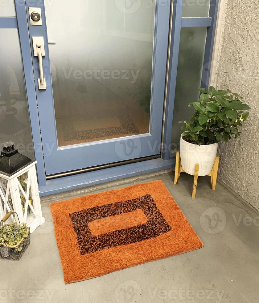 Designer Welcome Entry Doormat Placed Outside Entry Door with Plant and Lamp photo
