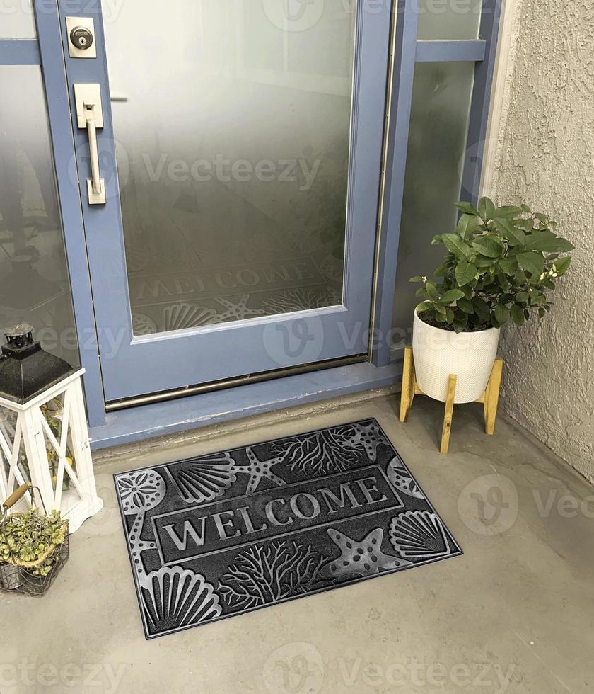 Designer Welcome Entry Doormat Placed Outside Entry Door with Plant and Lamp photo