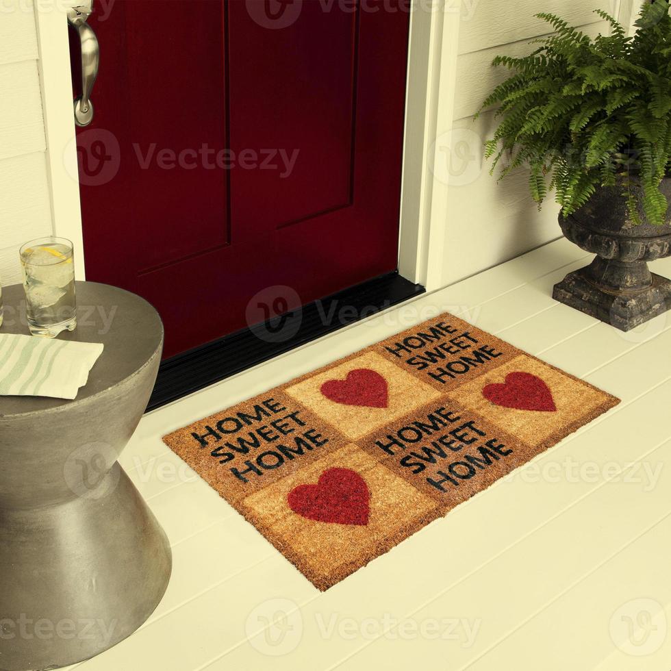 Designer Welcome Entry Doormat Placed on Floor Outside Entry Door with Plants and lemon ice drink photo