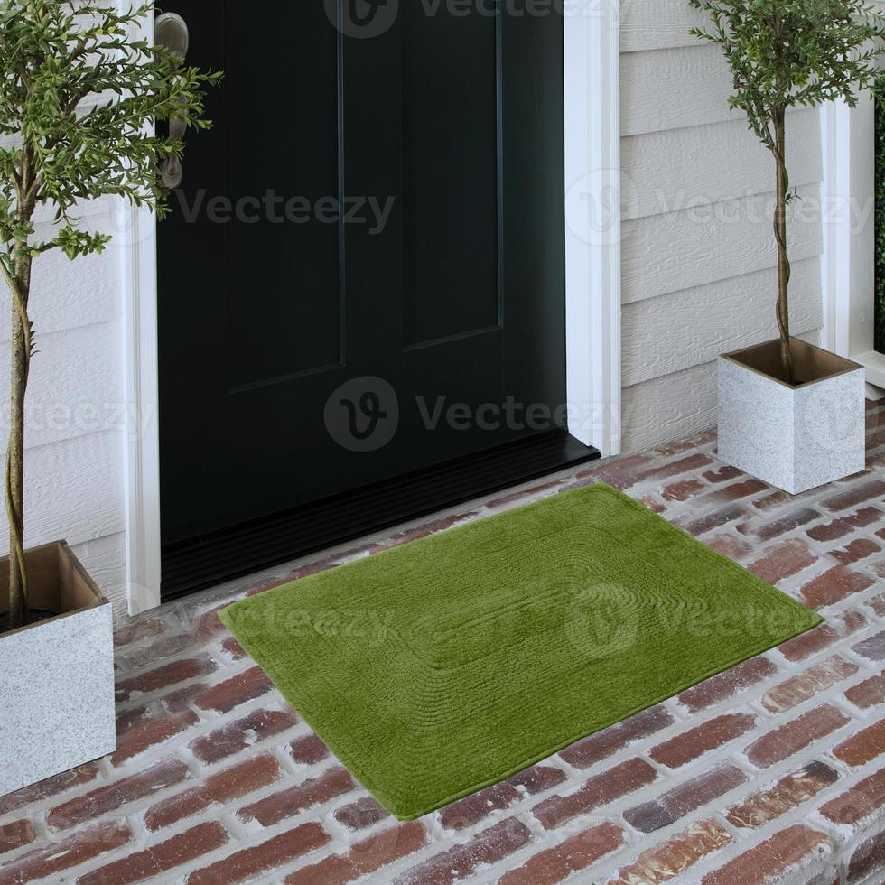 Designer Welcome Entry Doormat Placed on Solid Brick Floor Outside Entry Door with Plants photo