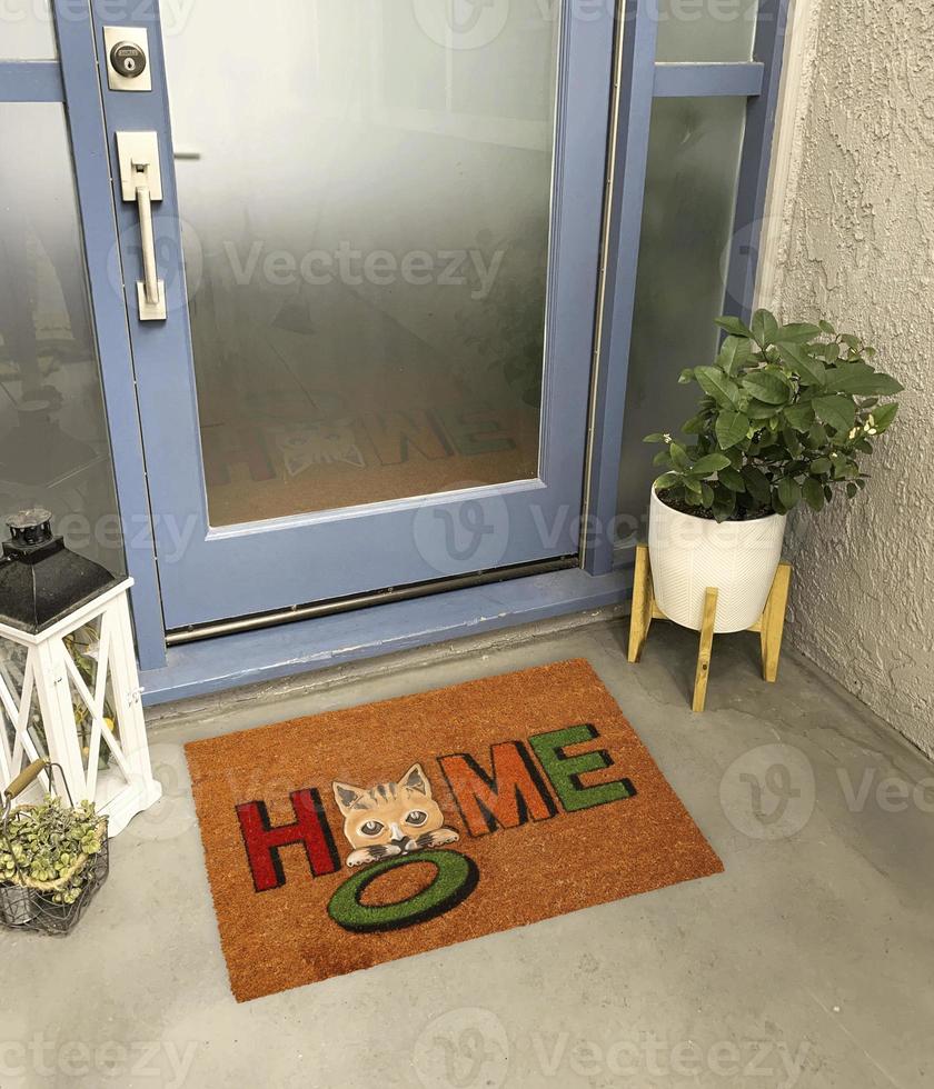 Designer Welcome Entry Doormat Placed Outside Entry Door with Plant and Lamp photo