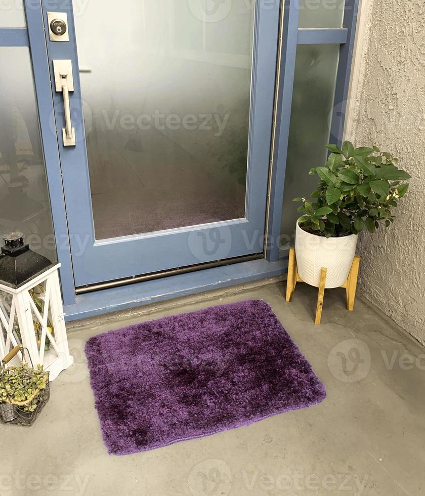 Designer Welcome Entry Doormat Placed Outside Entry Door with Plant and Lamp photo