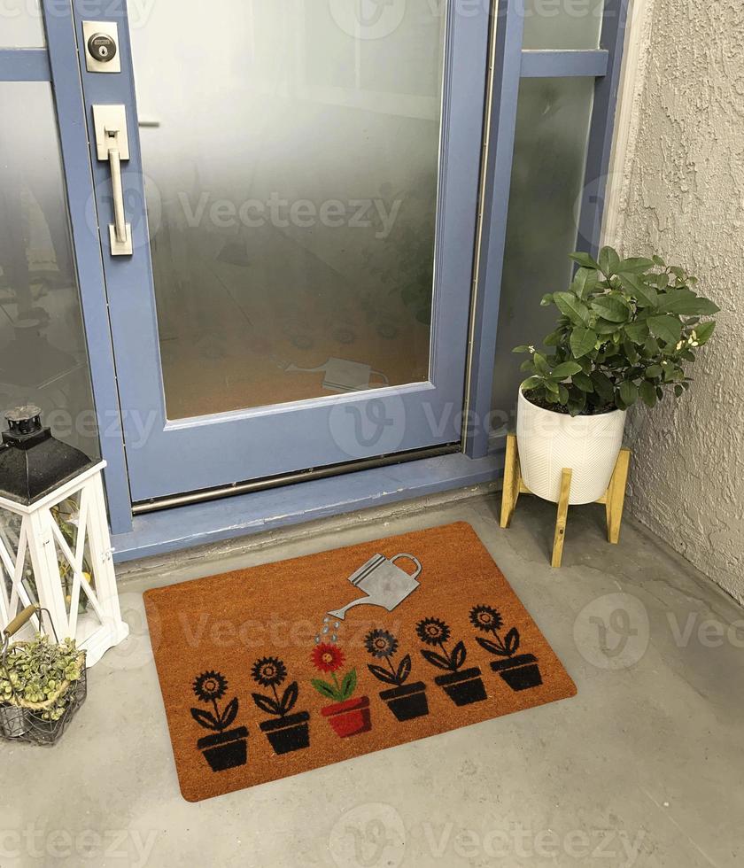 Designer Welcome Entry Doormat Placed Outside Entry Door with Plant and Lamp photo