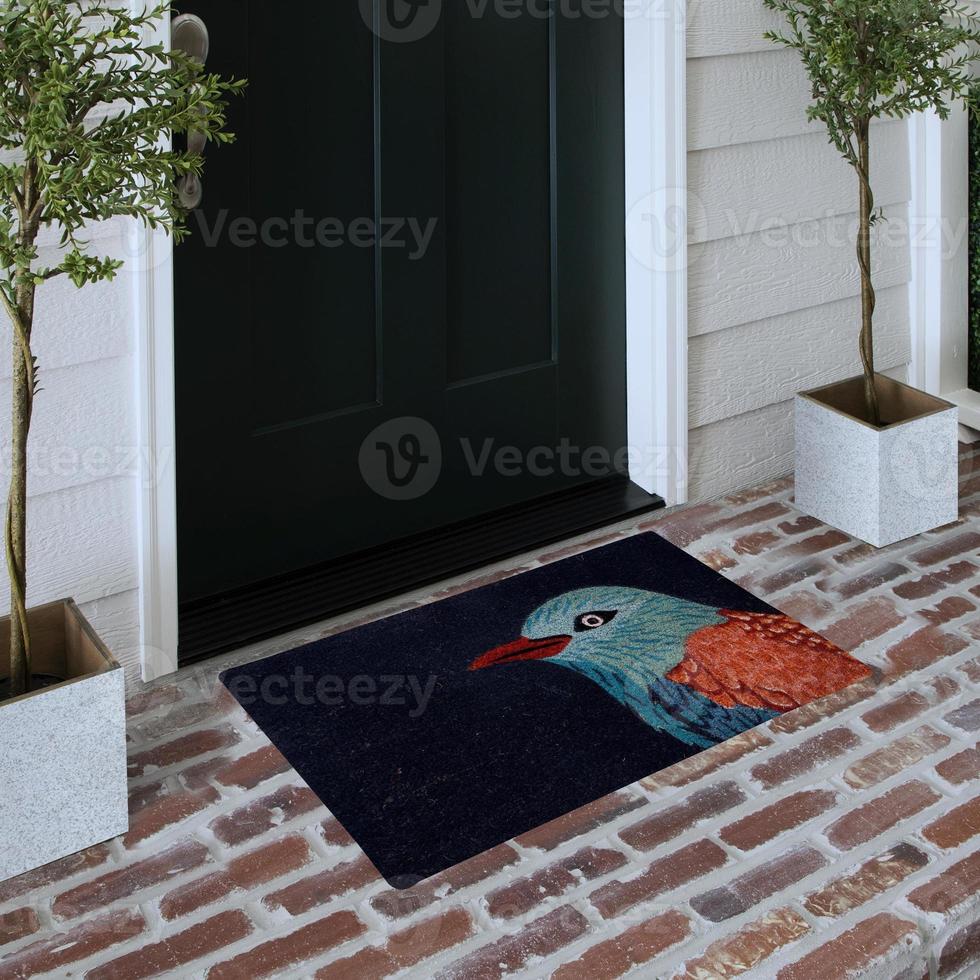 Designer Welcome Entry Doormat Placed on Solid Brick Floor Outside Entry Door with Plants photo