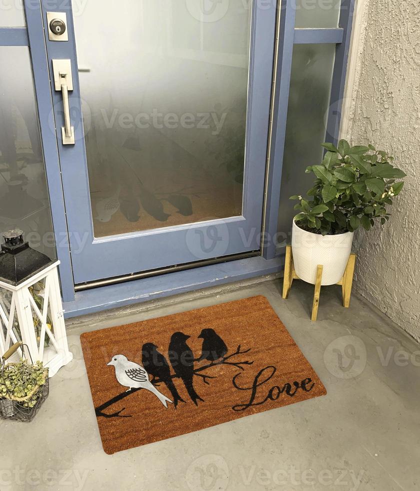 Designer Welcome Entry Doormat Placed Outside Entry Door with Plant and Lamp photo