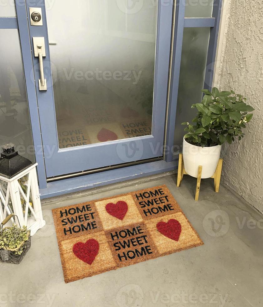 Designer Welcome Entry Doormat Placed Outside Entry Door with Plant and Lamp photo