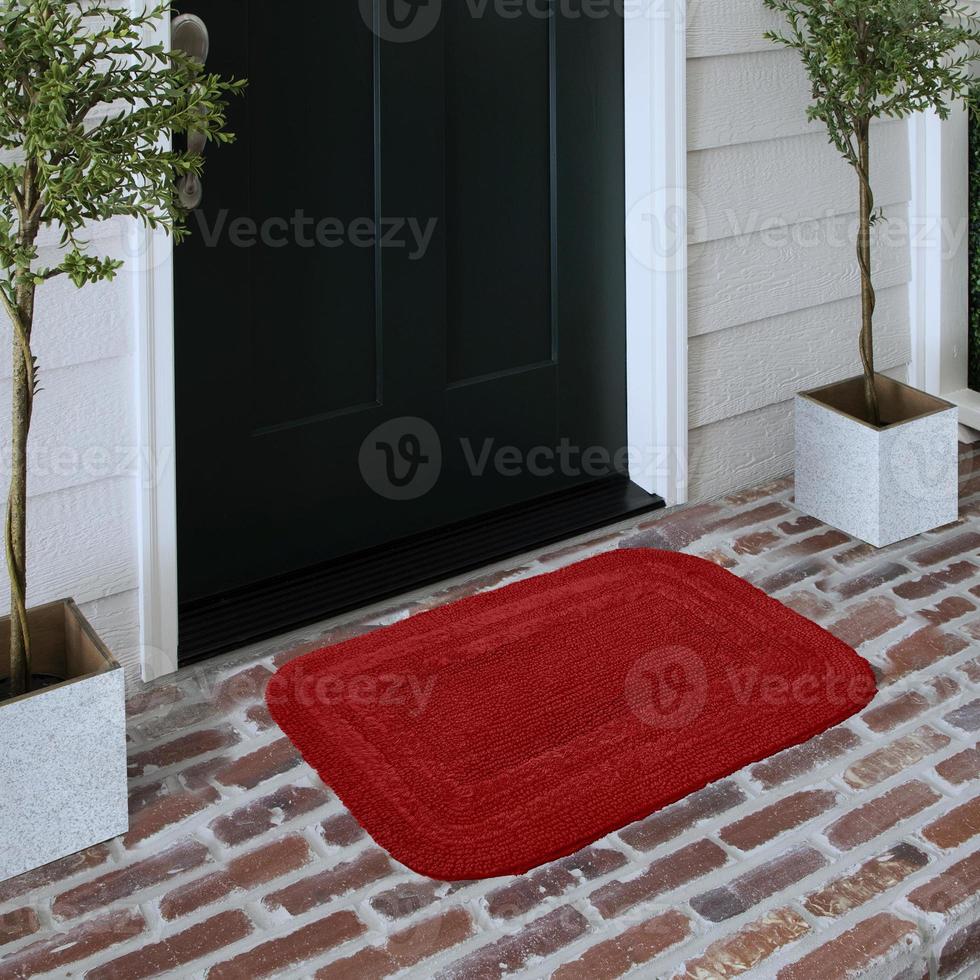 Designer Welcome Entry Doormat Placed on Solid Brick Floor Outside Entry Door with Plants photo