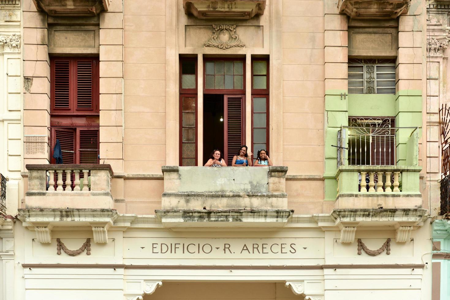 la habana, cuba - 7 de enero de 2016 - lugareños saludando desde un balcón a lo largo del paseo del prado en la habana, cuba. foto