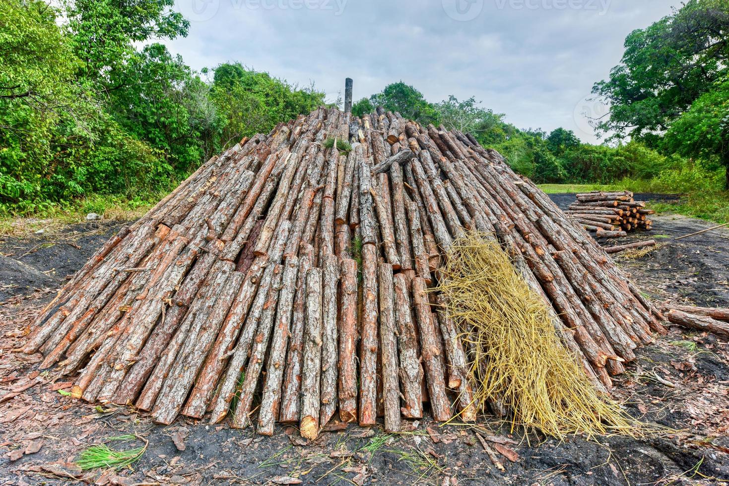 Wood pyre being prepared for the creation of charcoal from pine logs in Vinales, Cuba. photo