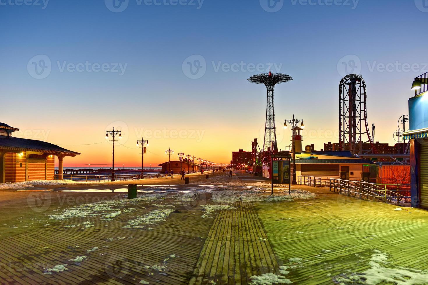 Coney Island Boardwalk with Parachute Jump in the background in Coney Island, NY. The boardwalk was built in 1923 and stretches for 2.51 miles photo