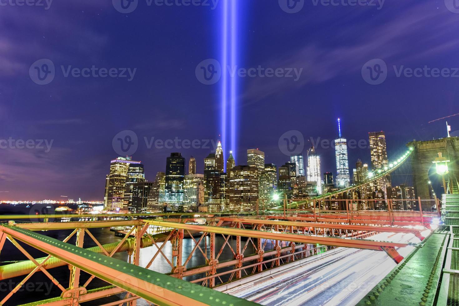 el horizonte del centro de manhattan de la ciudad de nueva york por la noche desde el puente de brooklyn con el tributo a la luz en memoria del 11 de septiembre. foto