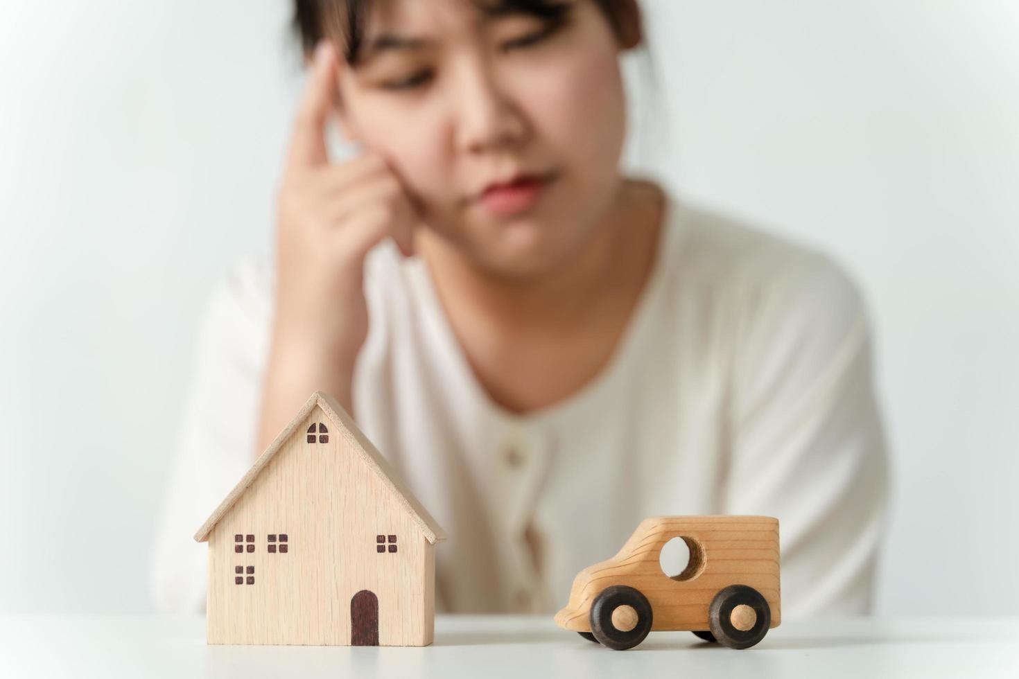 confused Asian woman buyer choosing between buying new home or car. photo