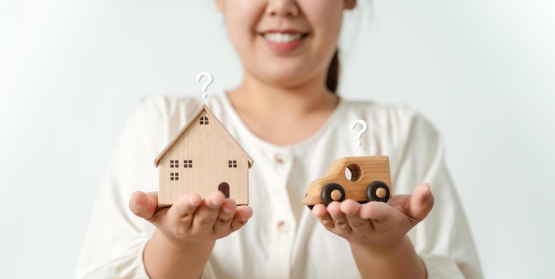 woman deciding to choose between buying new home or car with Question Marks, Planning to buy property. home loan, car finance concepts. photo