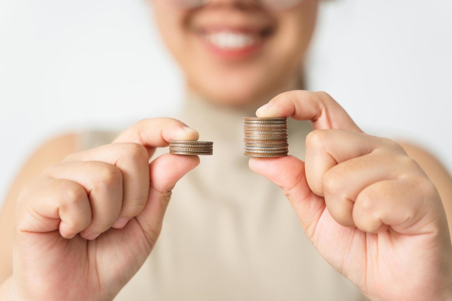 Hands compare two piles of coins of different sizes. photo