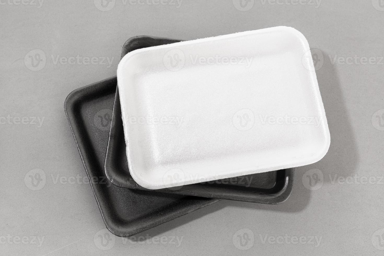 Group of styrofoam trays used for food. Black and white Disposable polystyrene trays isolated on gray background photo