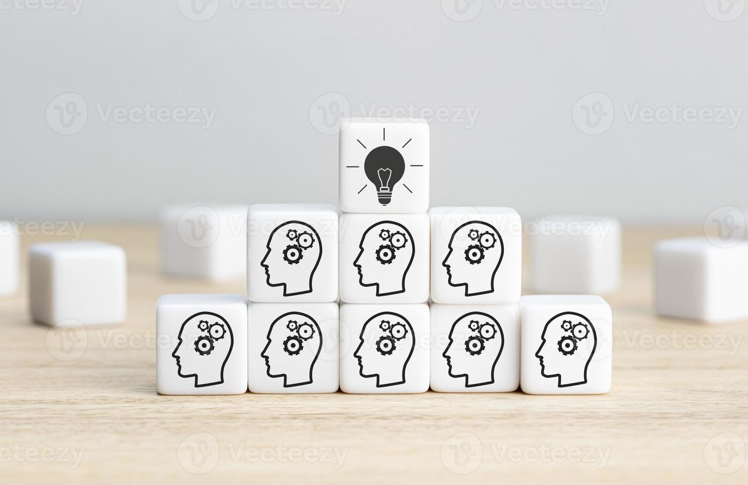 Team Brainstorming, creative idea or innovative idea concept. Cube blocks with gear head icon arranged in pyramid stair shape and a light bulb icon on top photo
