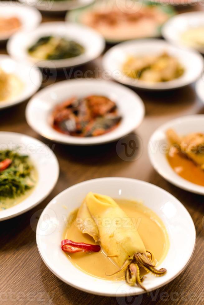 gulai cumi o calamar cocido condimento amarillo con leche de coco comida de indonesia foto