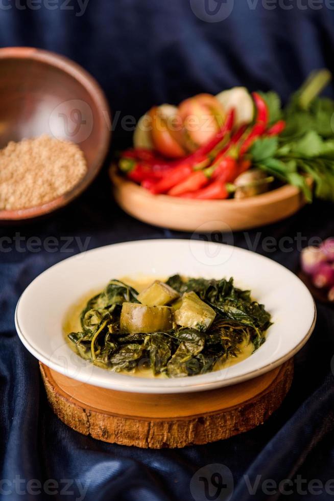 Cassava leaf curry is a traditional Indonesian dish, made from boiled cassava leaves, sliced, given coconut milk and spicy curry spices photo