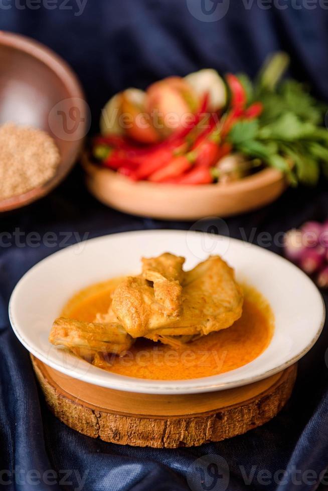 Rendang Ayam or Chicken Rendang, is an Indonesian food from West Sumatra in Indonesia. Chicken Rendang served on plate photo