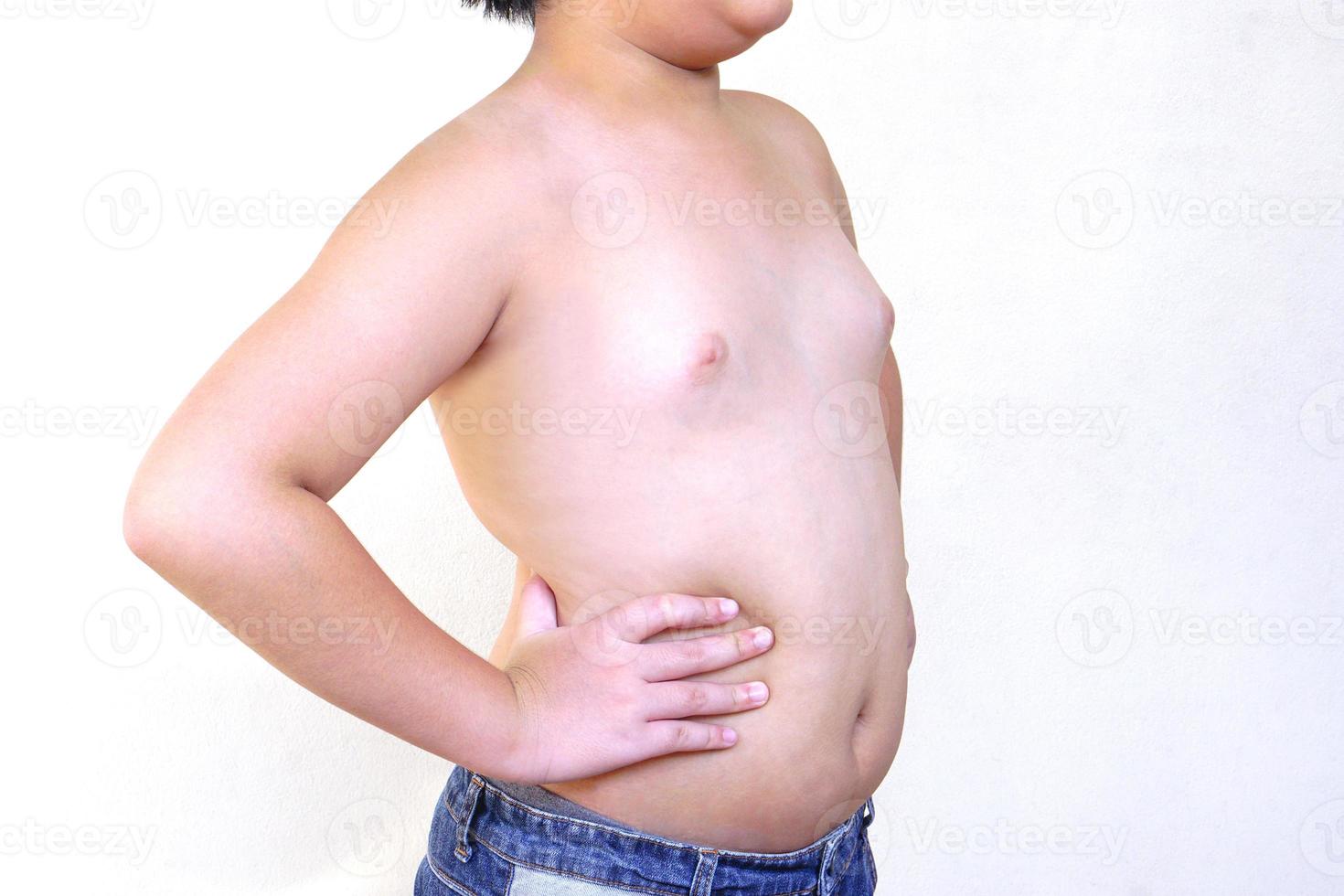 The fat boy wear jeans standing with arms akimbo on white background. Health and exercise concept. photo