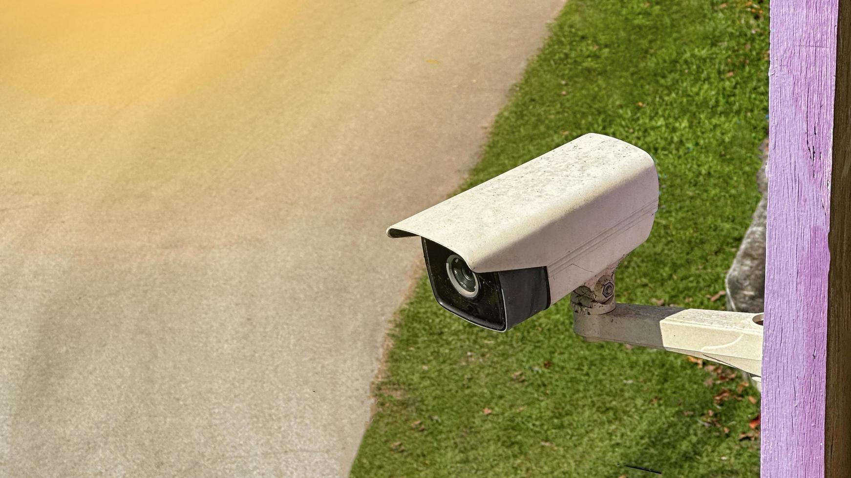 Old and dirty surveillance camera but it is still active installed at a house to provide safety for its inhabitants with the sun light photo