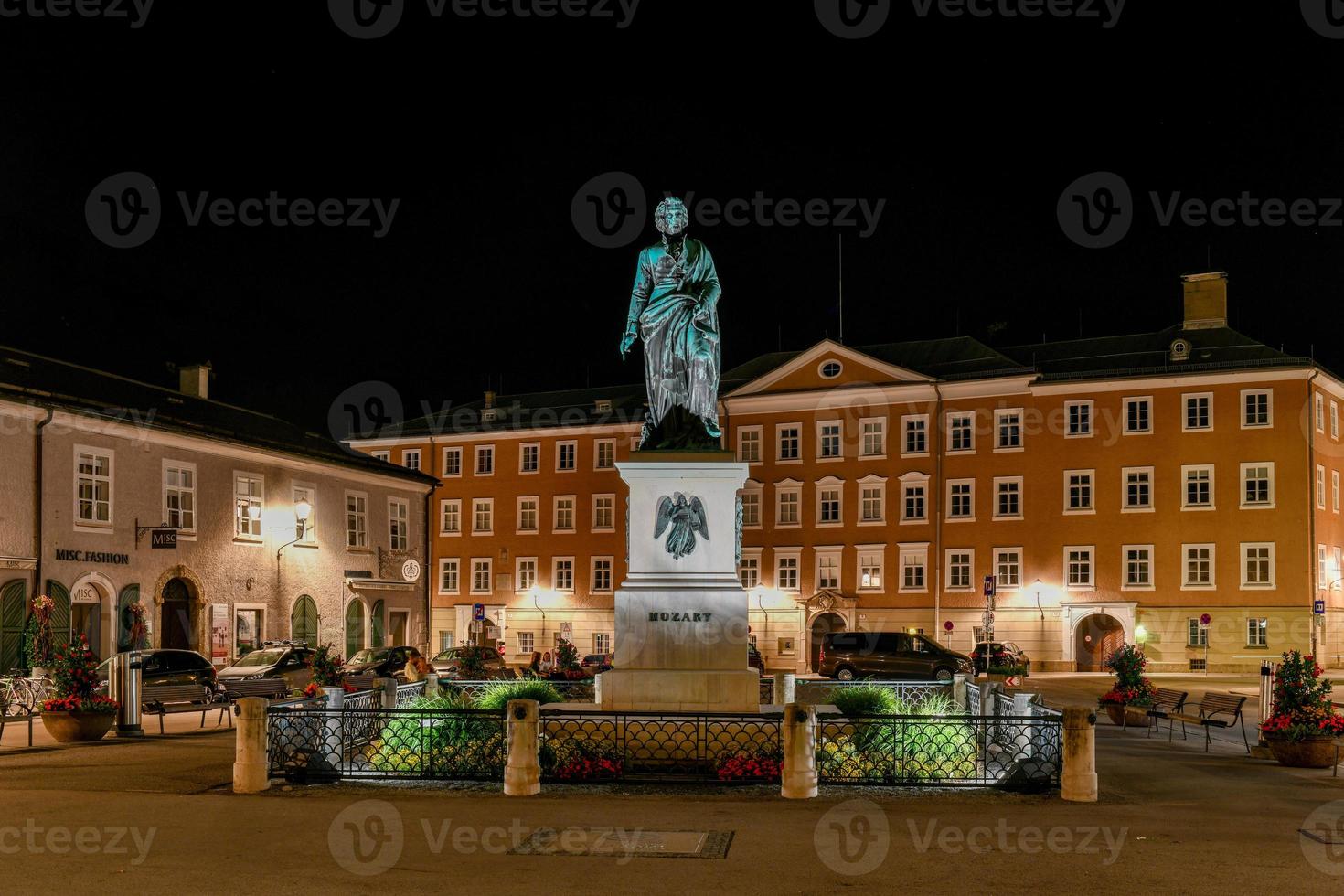 salzburgo, austria 10 de julio de 2021 en el centro de mozartplatz se encuentra la estatua de mozart de ludwig schwanthaler por la noche. , foto