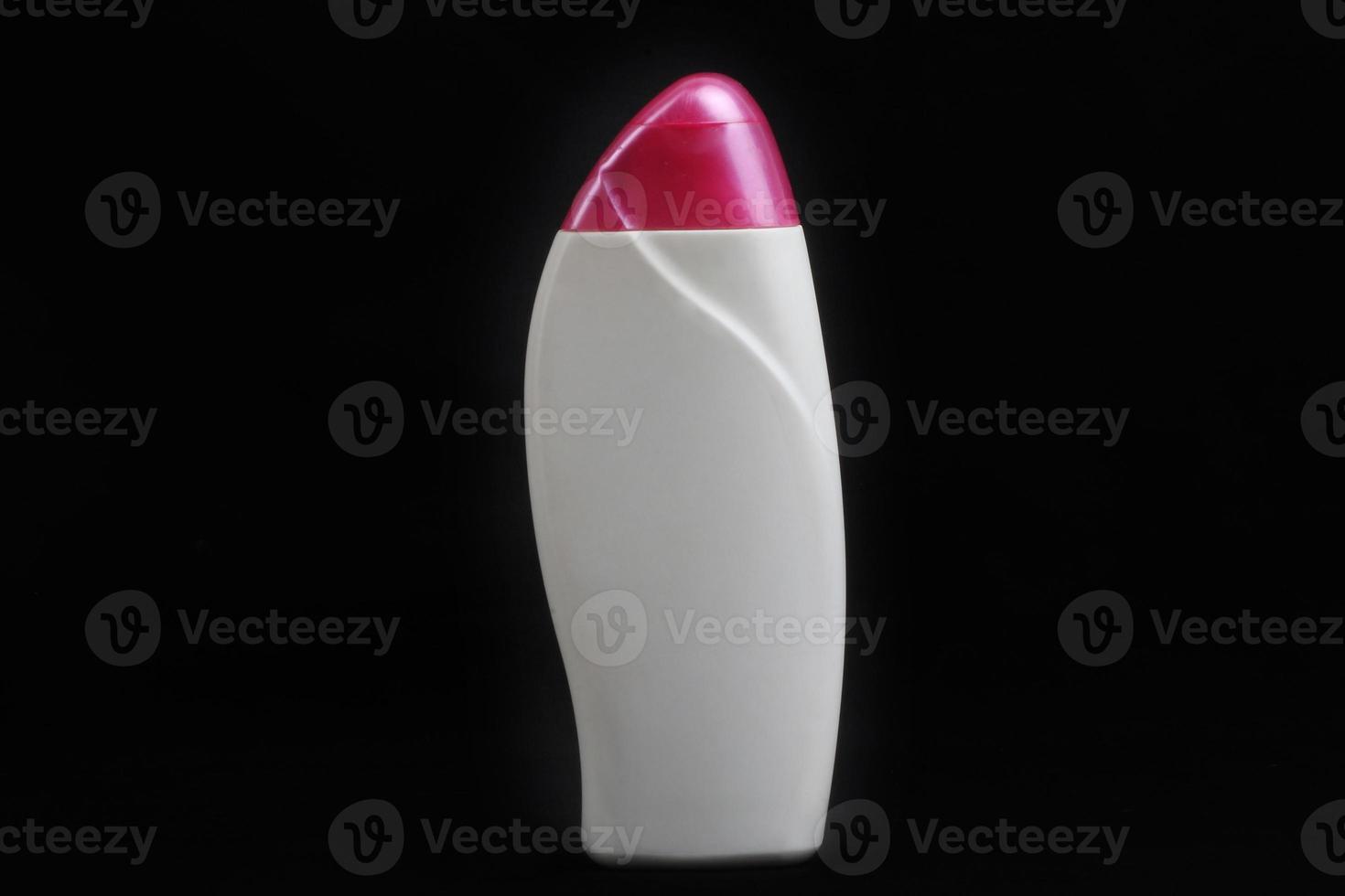 White pink body lotion bottle packaging on black background photo